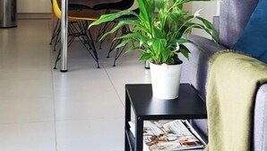 A modern living room with a sofa, a coffee table, and a dining area with a table and chairs.