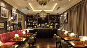 A bar area with a counter, seating, and a chandelier. - The Selwyn Hotel (Richmond)
