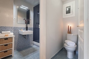 A bathroom with a white sink, a toilet, a shower, and a mirror. - Bright Design Flat near Sagrada Familia (Barcelona)