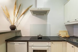 A kitchen with a stove, a dishwasher, and cabinets. - Bright Design Flat near Sagrada Familia (Barcelona)