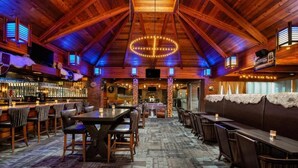 A rustic interior with wooden beams, a bar area, and seating arrangements. - Valhalla Hotel and Conference Centre (Thunder Bay)
