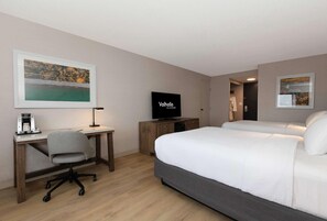 A hotel room with a bed, desk, chair, TV, and artwork on the walls. - Valhalla Hotel and Conference Centre (Thunder Bay)