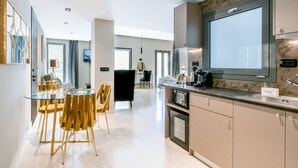 A modern kitchen with a built-in microwave, a coffee machine, and a large window. - Royalty Suites Psyrri (Athens)