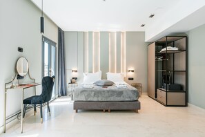 A modern bedroom with a bed, bedside tables, a desk, a chair, and a wardrobe. - Royalty Suites Psyrri (Athens)