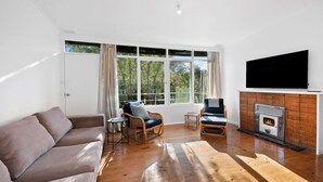 A living room with a sofa, two chairs, a TV, and a fireplace. - Anglesea Beach House 2 (Anglesea)