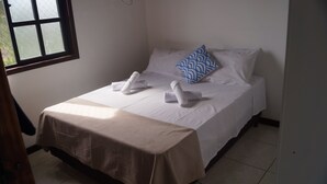 A neatly made bed with white linens and two towels folded at the foot. - CASA GORETE PRAIA DAS DUNAS RESIDENCE CLUB (Cabo Frio)