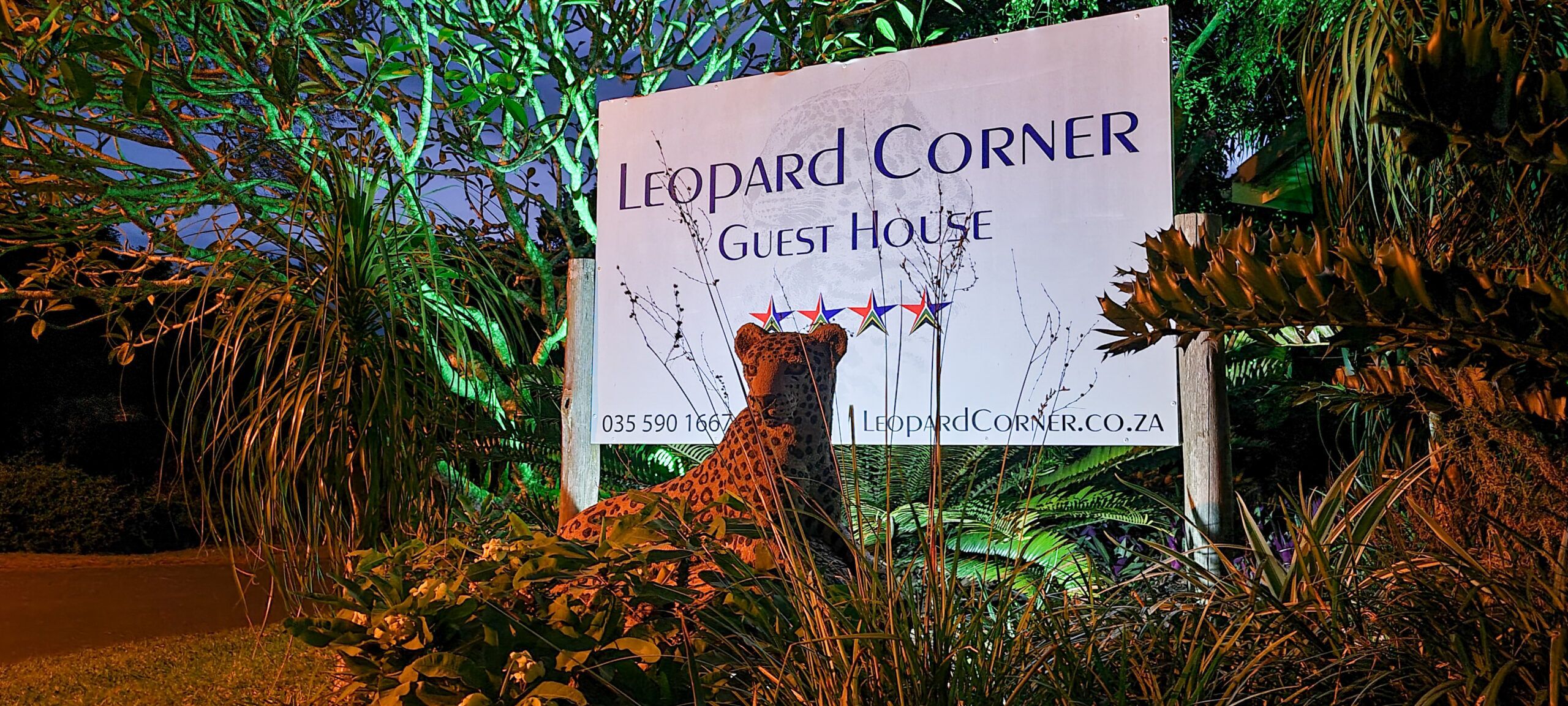 A sign for 'Leopard Corner Guest House' with a contact number and website.
