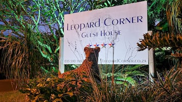 Señal para 'Leopard Corner Guest House', con un número de contacto y sitio web.