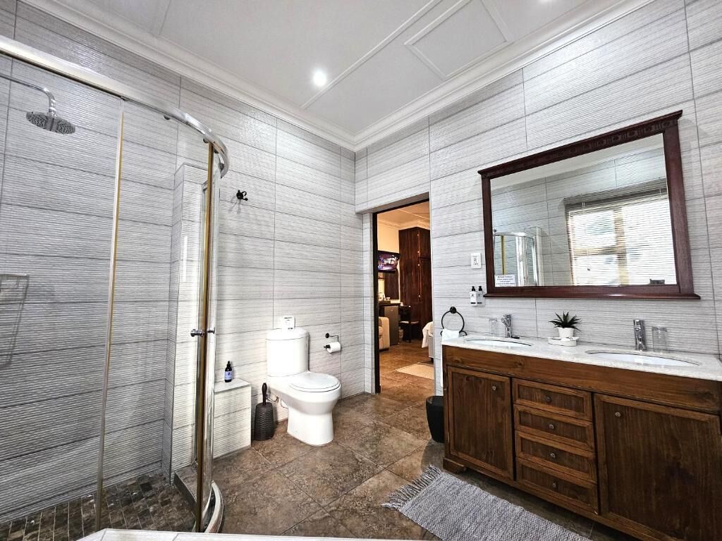 A bathroom with a shower, toilet, sink, and vanity.