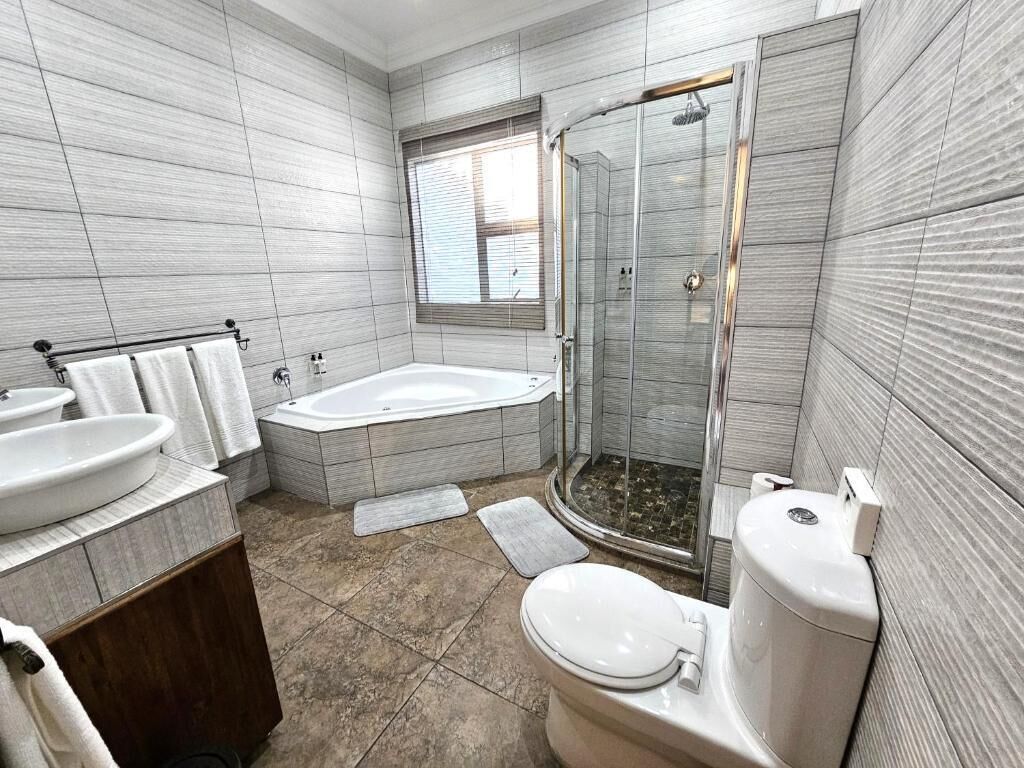 A bathroom with a bathtub, toilet, and shower.