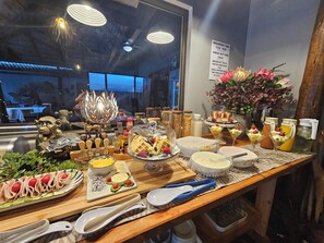 A buffet table with various food items and utensils. - Leopard Corner Lodge (St. Lucia)