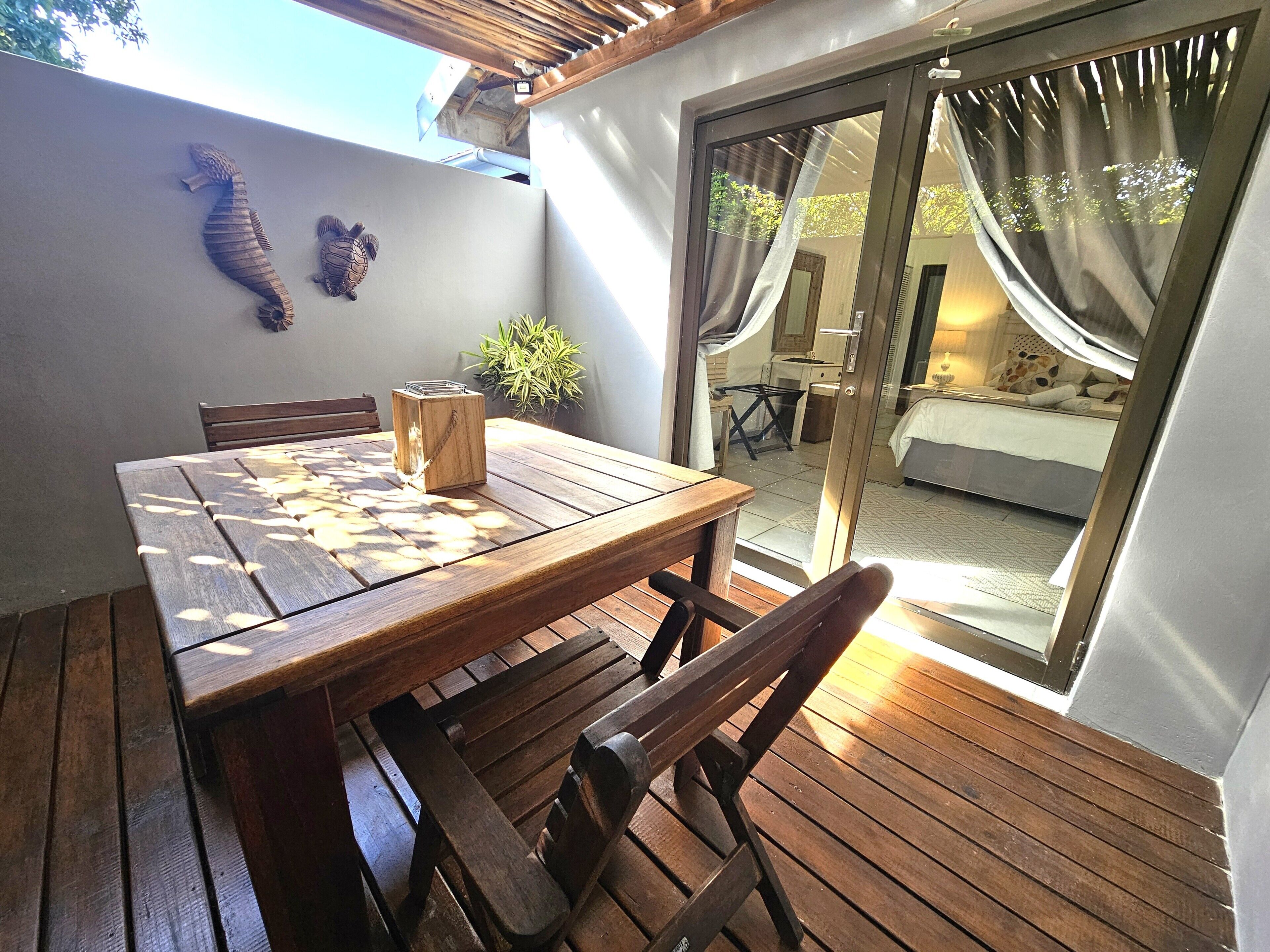 A wooden table with benches, a potted plant, and a seahorse decoration on the wall.