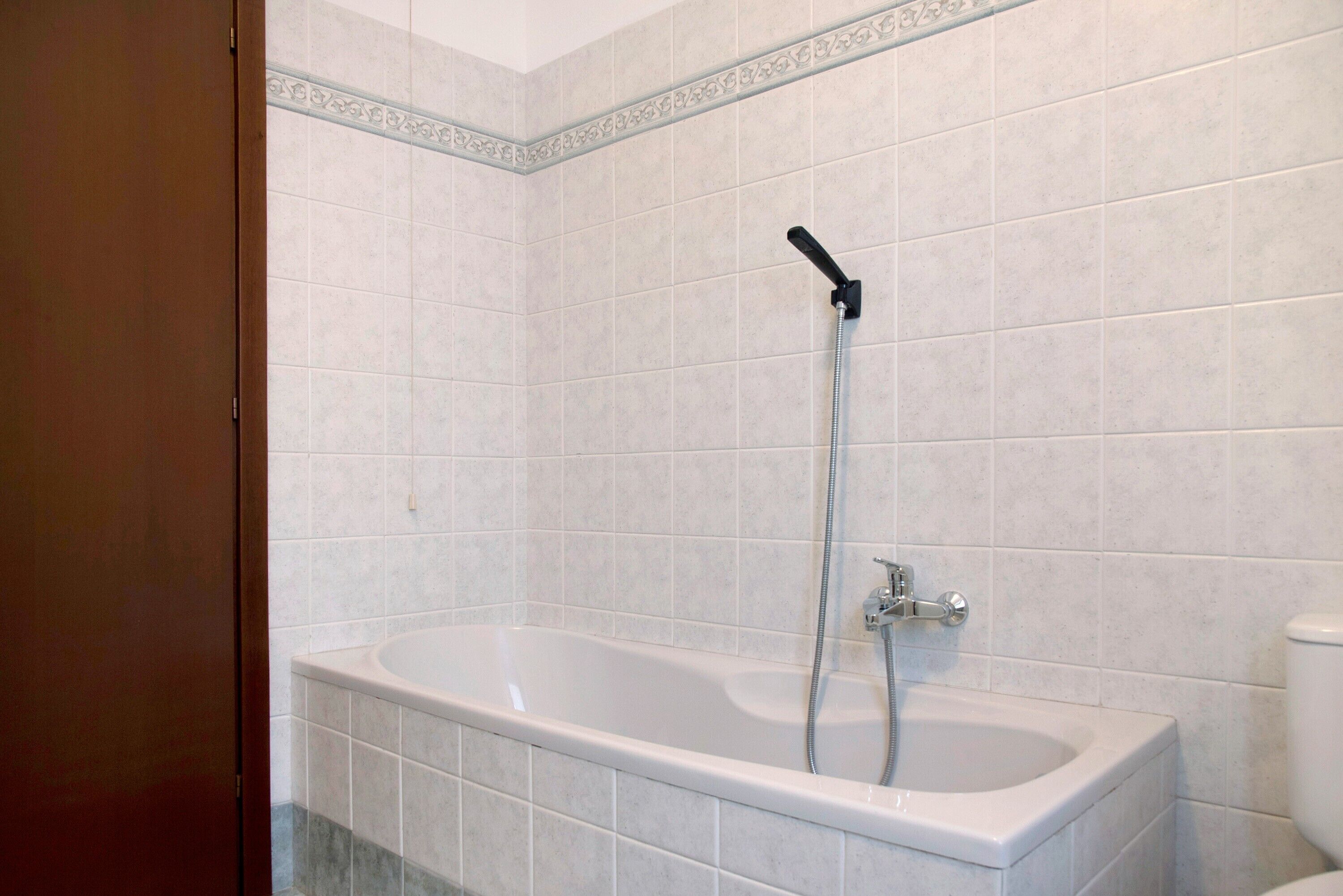 Une salle de bain avec une baignoire, une douche et des toilettes.