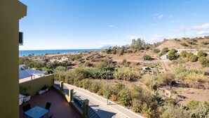 A balcony with a table and chairs, overlooking a hilly landscape with a view of the sea and a town in the distance. - Villa 'Pepa' with Sea Views, Heated Pool, and Wi-Fi (Chilches)