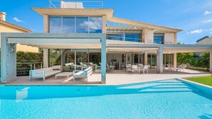 A modern house with a swimming pool, outdoor seating, and a covered patio. - Villa Agusmar with Sea View, Pool & Wi-Fi (llucmajor)