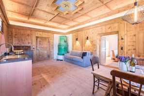 Un interno in legno con angolo cottura, zona pranzo e divano.