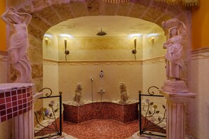 A bathroom with a tiled floor, a shower area, and two statues on either side.