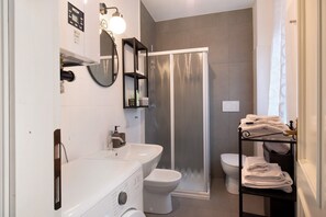 Une salle de bain moderne équipée d’une douche, de toilettes et d’un lavabo.
