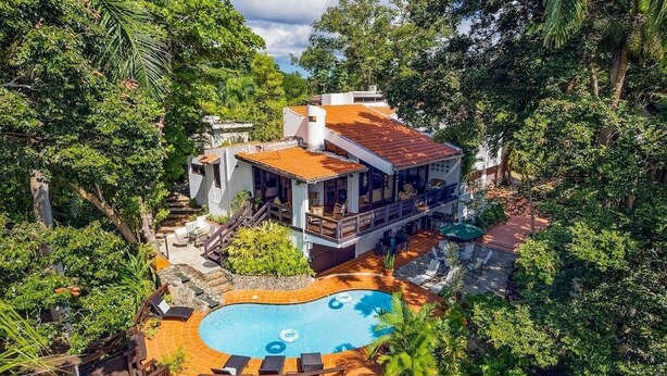 A house with a swimming pool surrounded by lush greenery. - Green Nest at the Hills (Guaynabo)