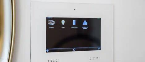 A thermostat with four control options: temperature, lights, video/audio, and settings.