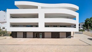 A modern multi-story building with a flat roof and a symmetrical facade.