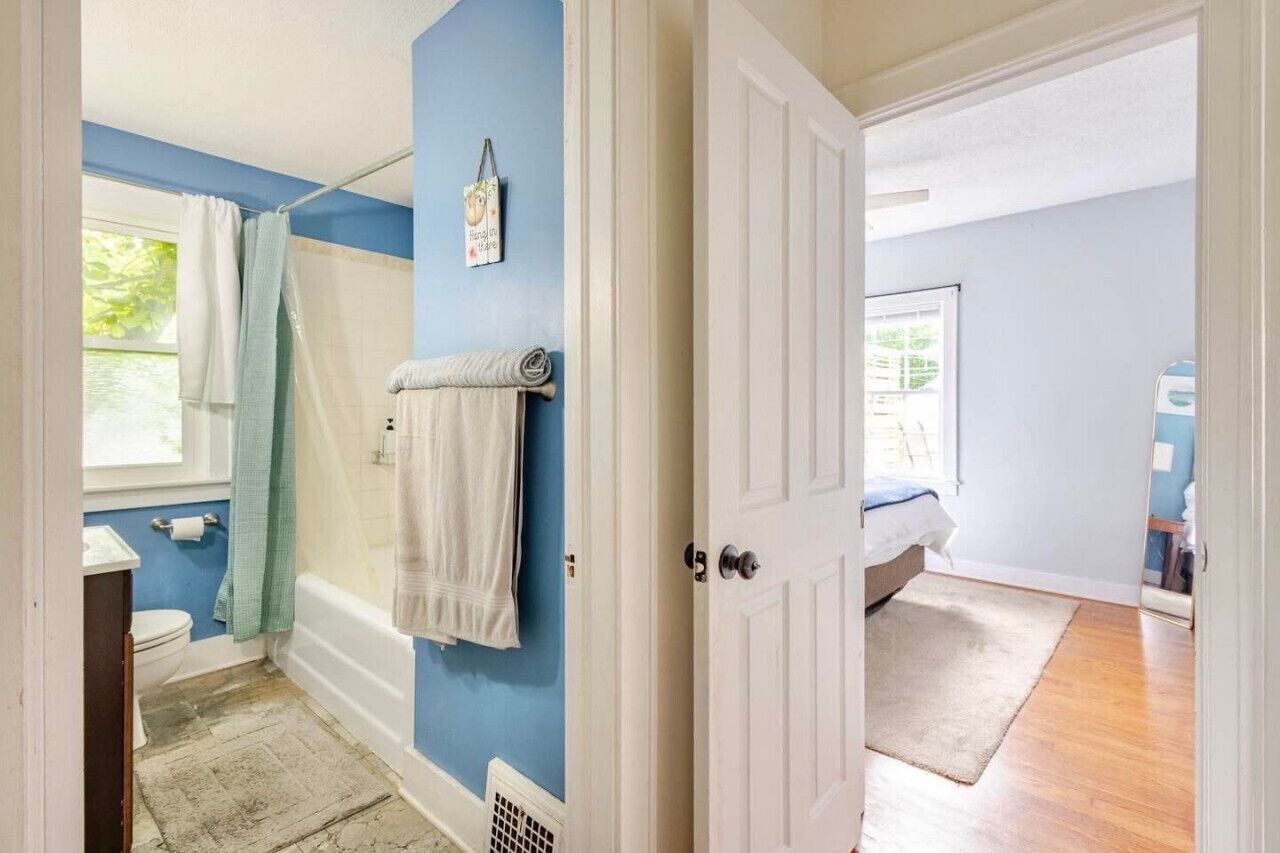 A bathroom with a bathtub, a toilet, and a shower curtain.