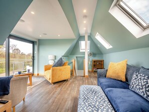 Un loft espacioso con techo alto, tragaluces y un gran ventanal con vistas al exterior.