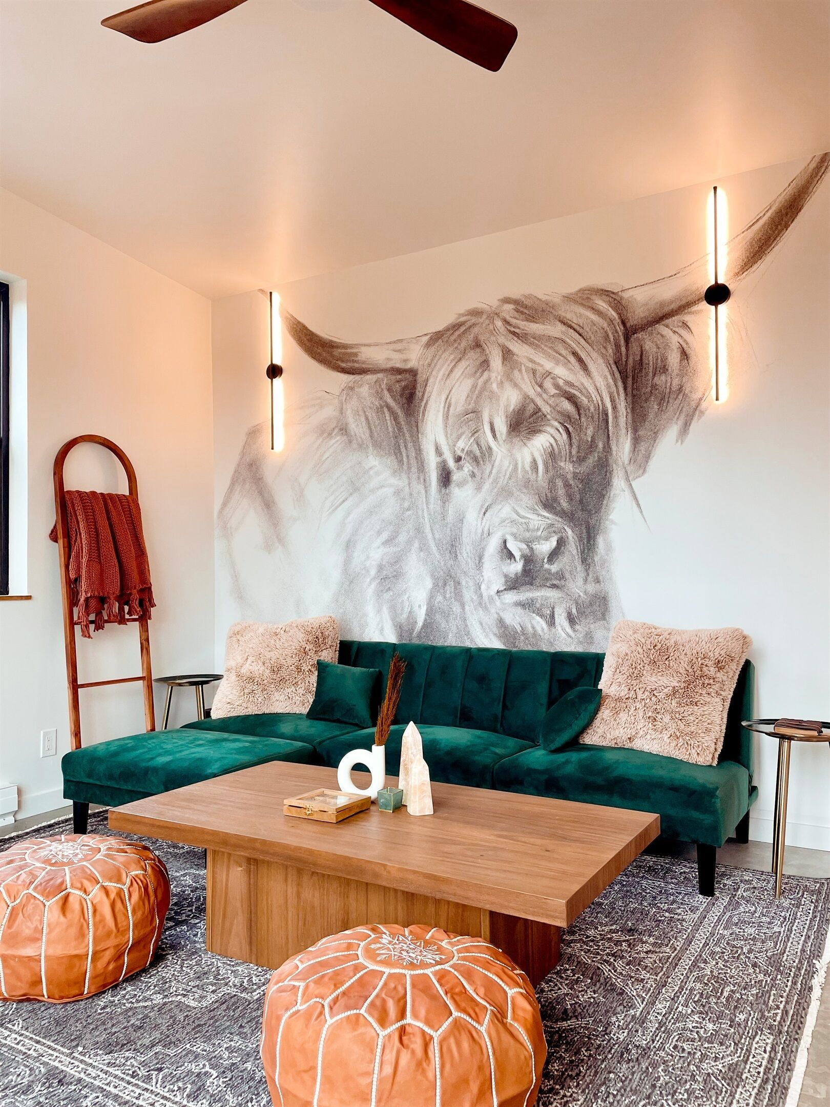 A modern living room with a green sofa, wooden coffee table, and orange poufs.