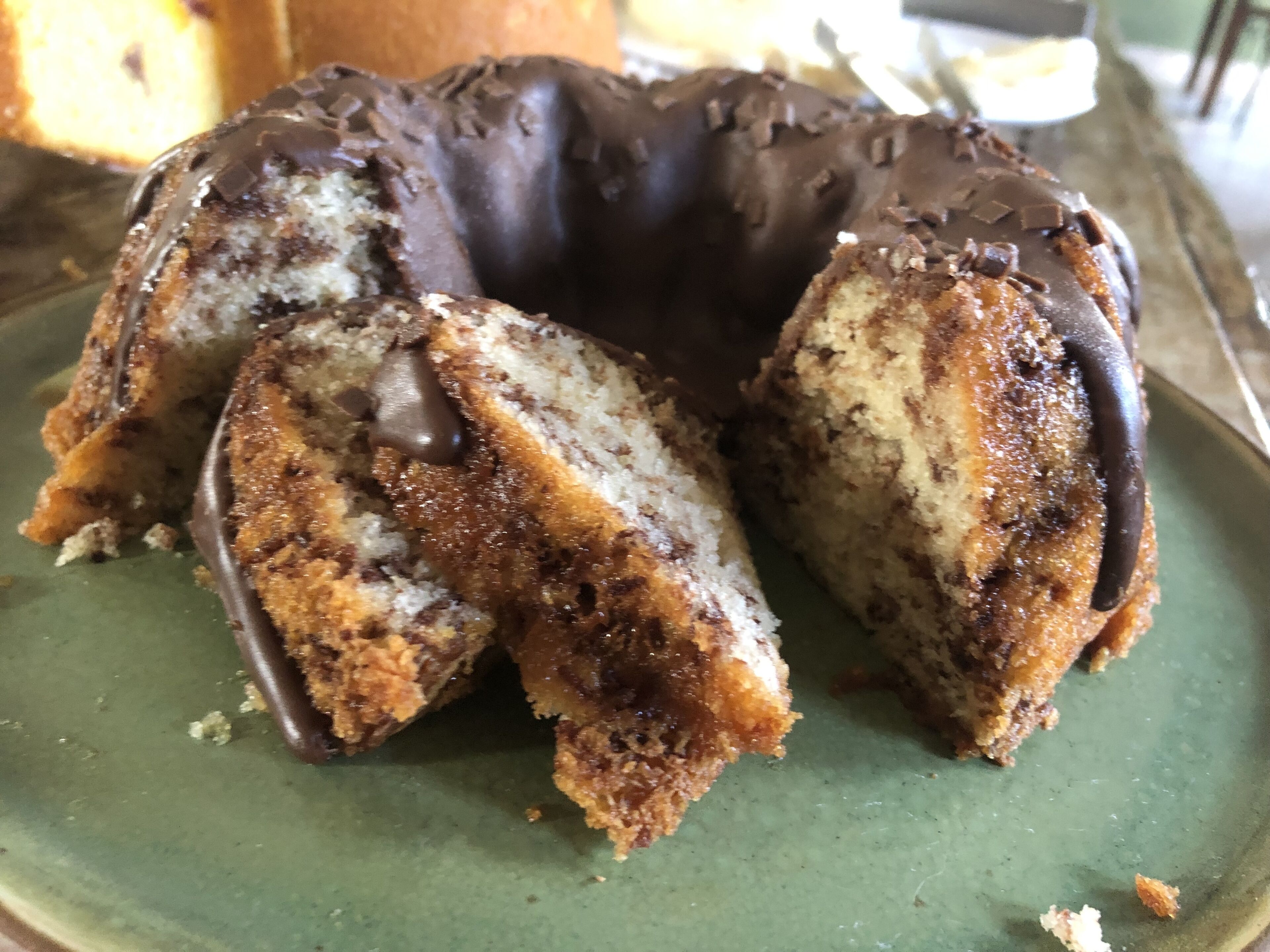 A chocolate-covered bundt cake with a slice cut out.