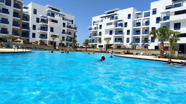 A swimming pool surrounded by multi-story buildings with balconies.