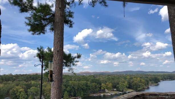 A stone wall overlooking a lake with boats, surrounded by trees and a clear sky. - Relaxing getaway at Honey's Condo (Hot Springs)