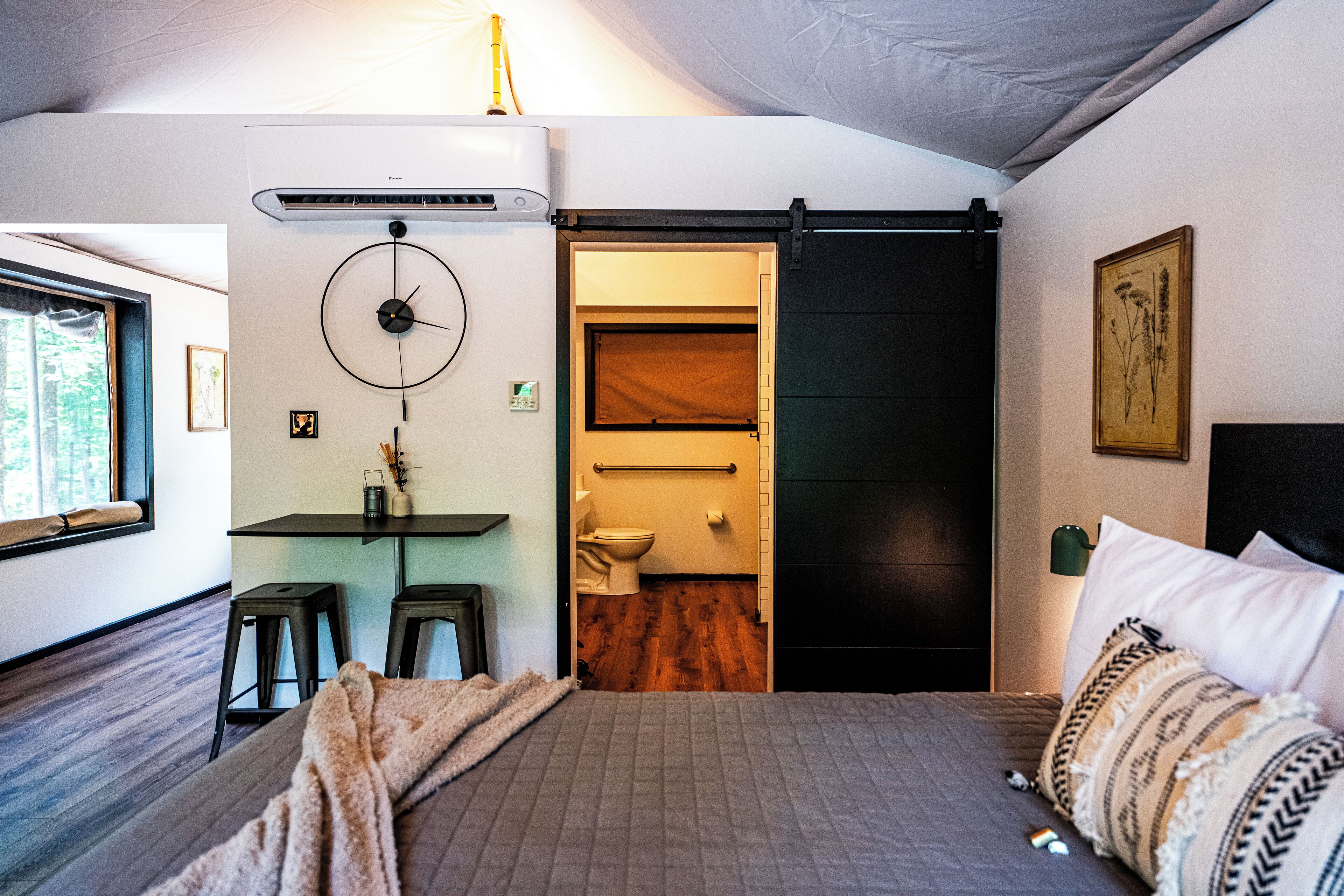 Un dormitorio con cama, escritorio y baño.