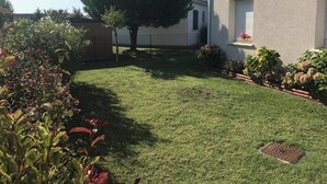 A well-maintained lawn with a large tree, a house with a window, and a fence. - Beautiful house near the ocean—peaceful, charming, and perfect for a family vacation (Meschers-sur-Gironde)
