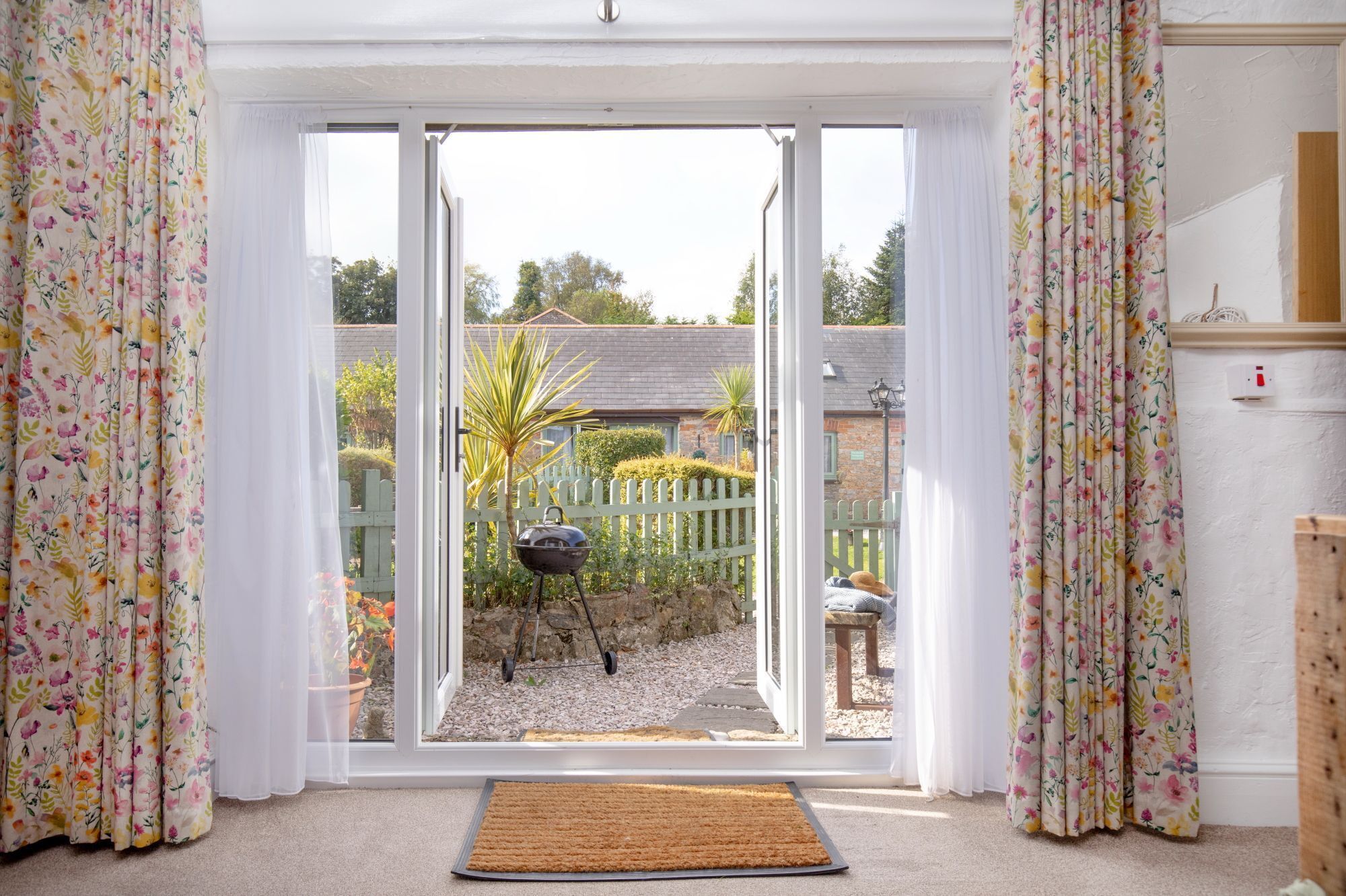 Een kamer met een schuifdeur van glas die uitkomt op een tuin.