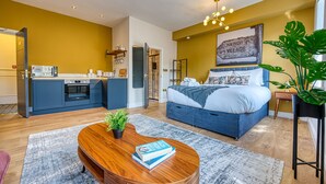 A modern bedroom with a bed, bedside table, and a large window. - Haworth Heights (Keighley)