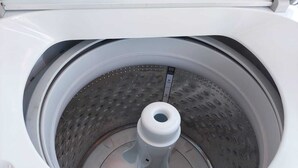 A white washing machine with a transparent drum and a control panel. - Apartment Luxe Next to Malls Central Location (Georgetown)