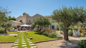 A house with a garden, a paved walkway, and outdoor furniture. - Locanda Della Meridiana - Alloro (Pula)