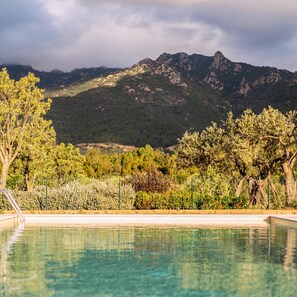 A pool with a mountain backdrop. - Locanda Della Meridiana - Olivo (Pula)