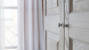 A white door with a simple handle and a window with a grid pattern. - Locanda Della Meridiana - Ginepro (Pula)
