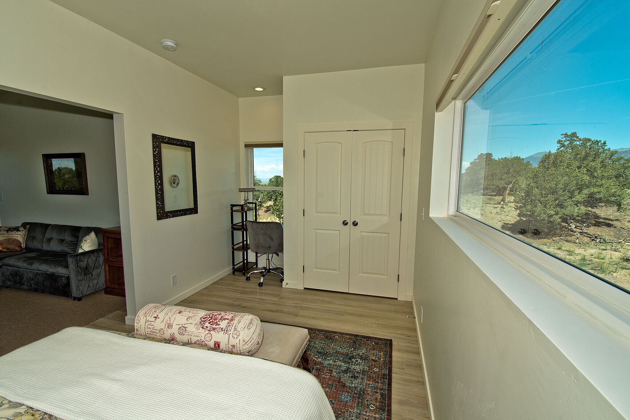 A bedroom with a bed, a desk, a chair, and a wardrobe.
