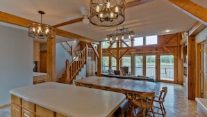 A spacious kitchen with a large island, wooden beams, and a chandelier. - Water Street Lodge! Waterfront 4 Bedroom, 4 Bath, Sleeps 12! (Marquette)