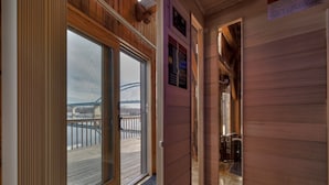 A wooden interior hallway leading to a balcony with a view of a bridge. - Water Street Lodge! Waterfront 4 Bedroom, 4 Bath, Sleeps 12! (Marquette)