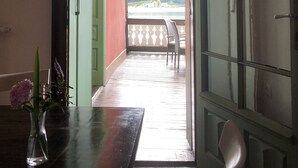 An open doorway leading to a balcony with a view of a mountainous landscape.