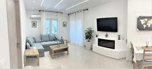 Relax in this stylish living room with a sofa, coffee table, fireplace, and large flat-screen TV.
