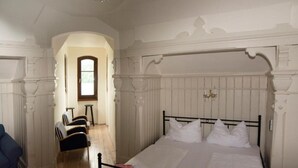 Une chambre avec un grand lit, une chaise et une petite table.