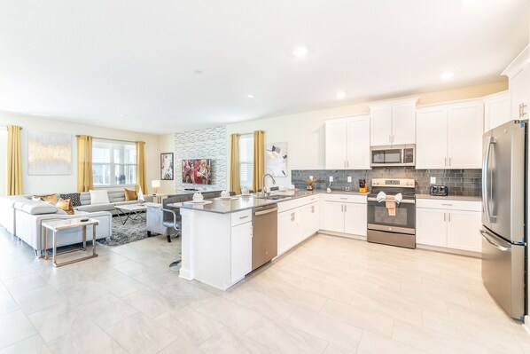 A modern kitchen with white cabinets, stainless steel appliances, and a central island. - Modern & Spacious Pool/SPA 19022 (Four Corners)