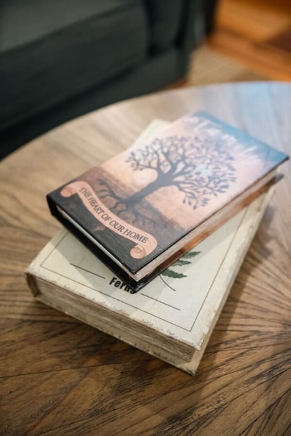 Una pila de libros con un diseño de árbol en la portada, sobre una superficie de madera.