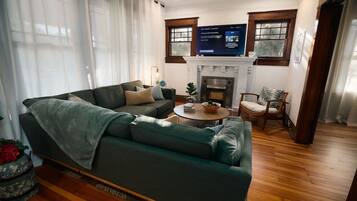 TV connectée, cheminée, livres, chaîne hi-fi