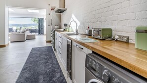 A modern kitchen with a dishwasher, a built-in oven, and a toaster. - 3 bedroom accommodation in Pontyates (Pontyates)