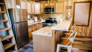Una cocina moderna con armarios de madera, electrodomésticos de acero inoxidable y una isla central con asientos.